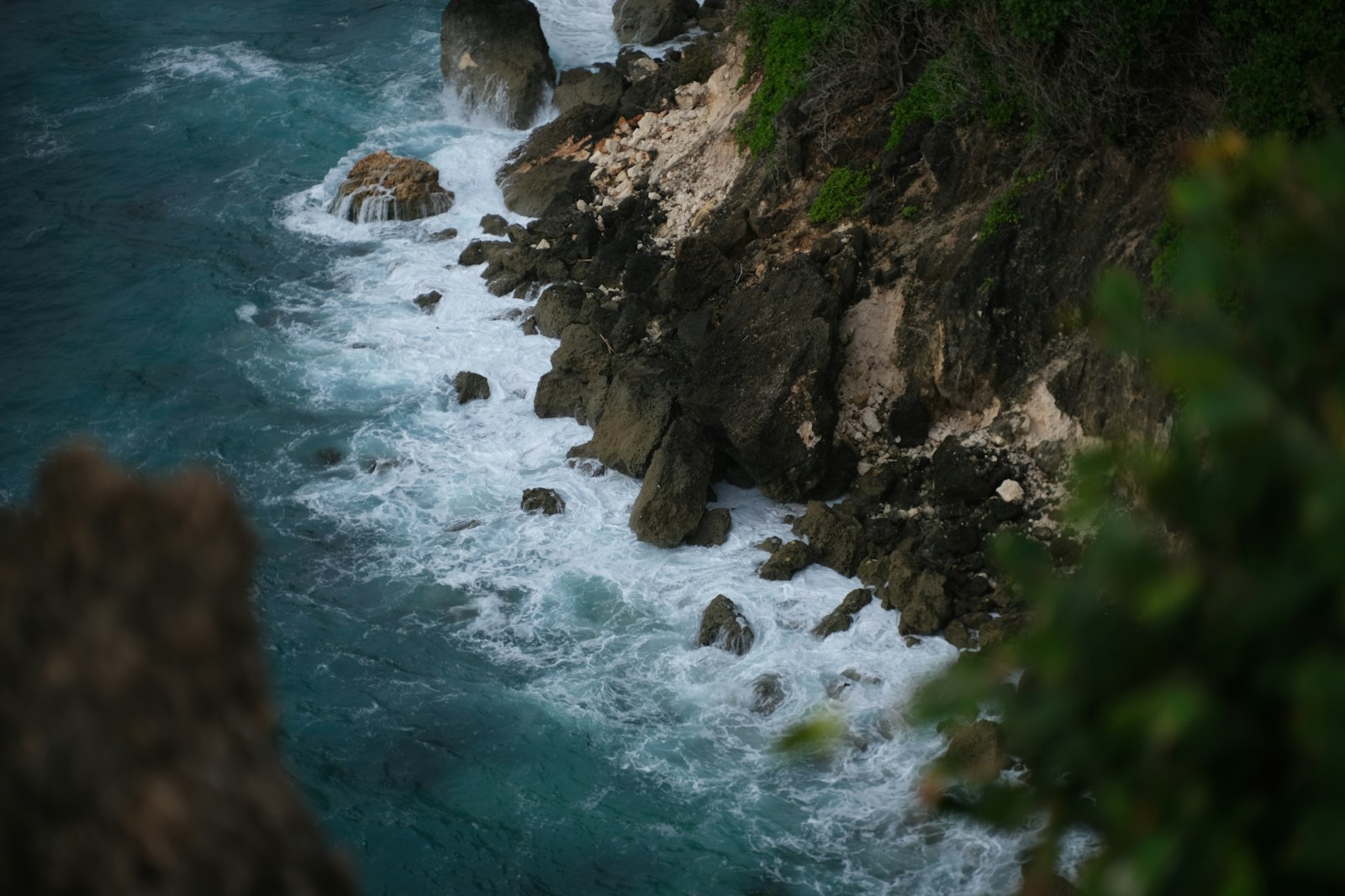 a rocky beach with a body of water in the background